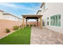 Manicured backyard features a paver patio, a gazebo structure, privacy wall, and a patch of artificial turf at 5384 Knitmore Ct, Las Vegas, NV 89139