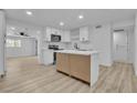 Open concept kitchen boasts an island, white cabinetry, and stainless appliances, perfect for modern living at 617 Stanford St, Las Vegas, NV 89107