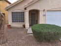 Welcoming home entrance with security door, manicured shrubbery, and desert landscaping for easy maintenance at 7209 London Bridge Ave, Las Vegas, NV 89130
