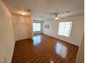 Bright living room featuring laminate flooring, neutral walls, and plenty of natural light from large windows at 7209 London Bridge Ave, Las Vegas, NV 89130