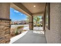 Inviting covered porch with stone pillars, perfect for enjoying the neighborhood views at 7877 Saber Tooth St, Las Vegas, NV 89149