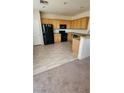 Well-lit kitchen with light wood cabinets, black appliances, and durable hard surface flooring at 10524 Congaree St, Las Vegas, NV 89141