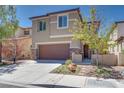 Tan two-story home with stone accents, a brown garage door, manicured landscaping, and a concrete driveway at 1427 Brushback Ave, Henderson, NV 89074