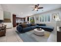 Open-concept living room featuring tile floors, modern furniture, and large windows with views of the backyard at 1427 Brushback Ave, Henderson, NV 89074