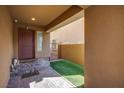 Inviting entryway with tiled flooring, artificial turf, a stylish door and a secure gate at 1794 Morro Vista Dr, Las Vegas, NV 89135