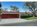 Charming single-story home with a well-manicured lawn and mature landscaping and a red tone at 1801 S 15Th St, Las Vegas, NV 89104