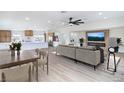 Open-concept living room with kitchen view, modern furniture, and large TV over electric fireplace at 1891 Brian Rd, Pahrump, NV 89048