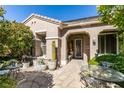 Inviting front porch with seating area, potted plants, and a stylish decorative door at 2184 Tiger Willow Dr, Henderson, NV 89012