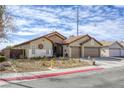 Single-story home featuring desert landscaping with rocks and plants, complemented by a charming tile roof at 2625 Torch Ave, North Las Vegas, NV 89081