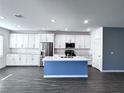 Bright kitchen boasts white cabinets, stainless steel appliances, large island, and modern finishes at 290 Mount Williamson St, Henderson, NV 89015