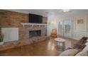 Cozy living room featuring hardwood floors, a brick fireplace, and a comfortable seating area at 3141 E Katie Ave, Las Vegas, NV 89121