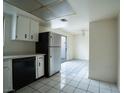 Bright eat-in kitchen with white cabinets, tile flooring, black appliances, and access to outdoor area at 3467 Garden East Dr, Las Vegas, NV 89121