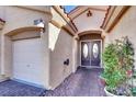 Close-up of the home's entrance, featuring a double door entry, brick walkway, and a well-maintained two car garage at 3837 Genoa Dr, Las Vegas, NV 89141