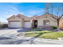 Beautiful one-story home showcasing a three-car garage, manicured lawn, and inviting entryway with decorative details at 3837 Genoa Dr, Las Vegas, NV 89141