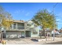 Two-story home features a two-car garage, balcony, and a lush, mature tree in the front yard at 401 Altamira Rd, Las Vegas, NV 89145