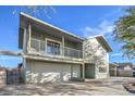Two-story home features a two-car garage, balcony, and a lush, mature tree in the front yard at 401 Altamira Rd, Las Vegas, NV 89145