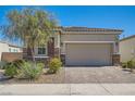 Attractive single-story home with a brick driveway, stone accents, and desert landscaping at 4708 Mindful St, North Las Vegas, NV 89031