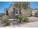 Inviting single-story home featuring a stone facade, neat landscaping, and a brick driveway at 4708 Mindful St, North Las Vegas, NV 89031