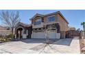 Elegant two-story home with a three-car garage, stone facade, and driveway leading to an arched gate at 6377 Elizabethtown Ave, Las Vegas, NV 89110