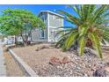View of the home exterior featuring a desert landscaped yard with mature trees at 645 Utah St, Boulder City, NV 89005