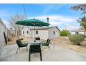 A backyard patio furnished with a table, chairs, and green umbrella for outdoor relaxation at 657 Burton St, Henderson, NV 89015