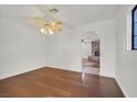 Dining room with hardwood floors, ceiling fan, and an archway leading to the living area at 657 Burton St, Henderson, NV 89015