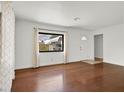 Bright living room with hardwood floors, large window, and neutral color palette offers a cozy space at 657 Burton St, Henderson, NV 89015