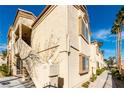 Exterior shot of a condo with stairs and tan stucco and an arched window at 7061 Roscoe Ave # 201, Las Vegas, NV 89129