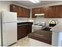 Functional kitchen with dark wood cabinets, granite countertops, and modern white appliances at 8244 Sickle Ln, Las Vegas, NV 89128
