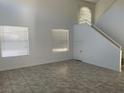 Spacious, naturally lit living room with tile flooring and a staircase leading upstairs at 8244 Sickle Ln, Las Vegas, NV 89128