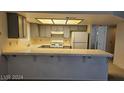 Neutral-toned kitchen with light countertops and cabinets plus a breakfast bar for casual dining at 8316 Classic Villa Ct, Las Vegas, NV 89128