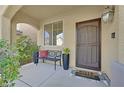 Charming front porch features a cozy bench, potted plants, and a welcoming doormat at 10449 Yew Blossom Ave, Las Vegas, NV 89166