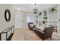 Stylish living room with decorative shelving, two leather chairs, and an eye-catching chandelier at 10449 Yew Blossom Ave, Las Vegas, NV 89166