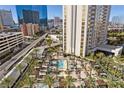 Upscale pool area with palm trees, lounge chairs, cabanas, and a view of the city skyline at 135 E Harmon Ave # 221, Las Vegas, NV 89109