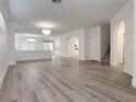 Bright, open-concept living room with hardwood floors, a modern chandelier, and an archway at 150 Short Ruff Way, Las Vegas, NV 89148