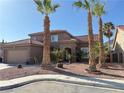 Stunning desert home showcasing a two-car garage and beautiful palm trees enhancing the curb appeal at 1893 Donnington Ct, Las Vegas, NV 89123