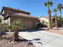 Attractive single Gathering home featuring desert landscaping, palm trees, and a two-car garage at 1893 Donnington Ct, Las Vegas, NV 89123