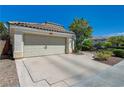 Exterior elevation of a single-story home featuring a well maintained yard and 2-car garage at 2024 Riva Del Garda Pl, Las Vegas, NV 89134