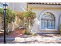 Exterior facade featuring an arched window and lush landscaping with a tiled walkway at 2611 S Durango Dr # 102, Las Vegas, NV 89117