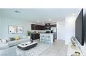 Bright, open-concept living area flows into kitchen with dark cabinets, stainless appliances, and breakfast bar at 3542 Arcadian King Ave, Las Vegas, NV 89106
