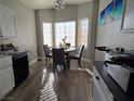 Bright dining area with a round table, large windows, and modern lighting fixture at 3836 Quail Creek Dr, North Las Vegas, NV 89032