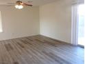 Bright living room with wood-look flooring and access to the backyard via sliding glass door at 3916 Via Lucia Dr, Las Vegas, NV 89115