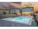 Resort-style backyard with a sparkling pool, covered patio, and lush greenery for relaxation at 4243 Tarim St, Las Vegas, NV 89147