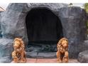 Tranquil pool grotto featuring carved lion statues, jacuzzi, and stone construction at 4745 Gunlock Cir, North Las Vegas, NV 89031