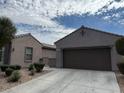 Single story home featuring a two car garage, desert landscaping and concrete driveway at 5525 Criollo Dr, Las Vegas, NV 89122