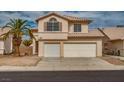 Two-story home boasts a three-car garage and a desert landscape, complete with a palm tree at 6276 Back Woods Rd, Las Vegas, NV 89142