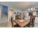 Inviting dining area with wooden table, stairs in the background, and modern light fixture at 6470 Crest Estates St, Las Vegas, NV 89131