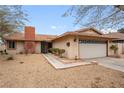 Charming single-story house with xeriscaping, a two-car garage, and a brick chimney for added curb appeal at 6858 Groveview Ln, Las Vegas, NV 89103