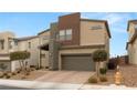 Modern home with neutral colors, two-car garage, desert landscaping, and paver driveway at 6901 Whisper Canyon Pl, North Las Vegas, NV 89084