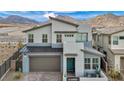 Modern two-story home featuring a stylish turquoise front door, desert landscaping, and mountain backdrop at 705 Carlon Hills Ave, Las Vegas, NV 89138